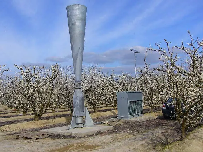 Canhão anti-granizo instalado em um pomar em flor