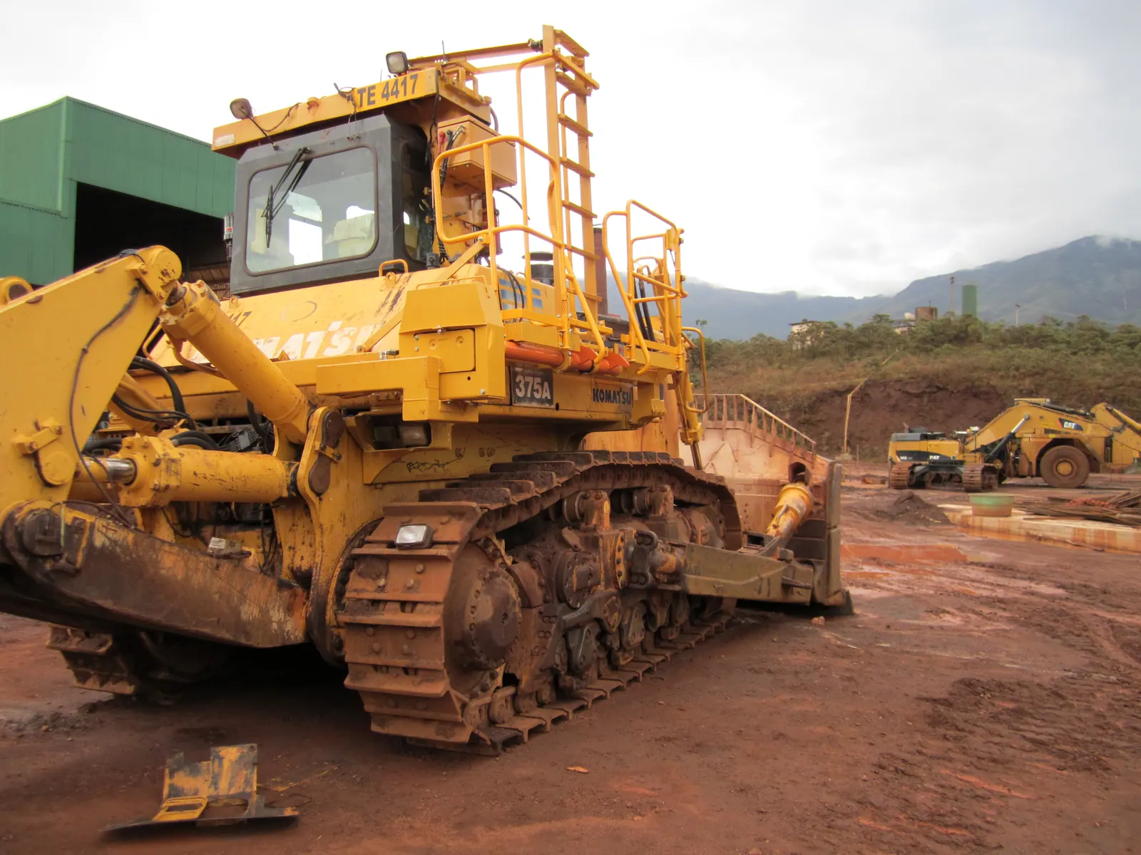 Trator de esteira com escada de acesso e plataforma junto à cabine