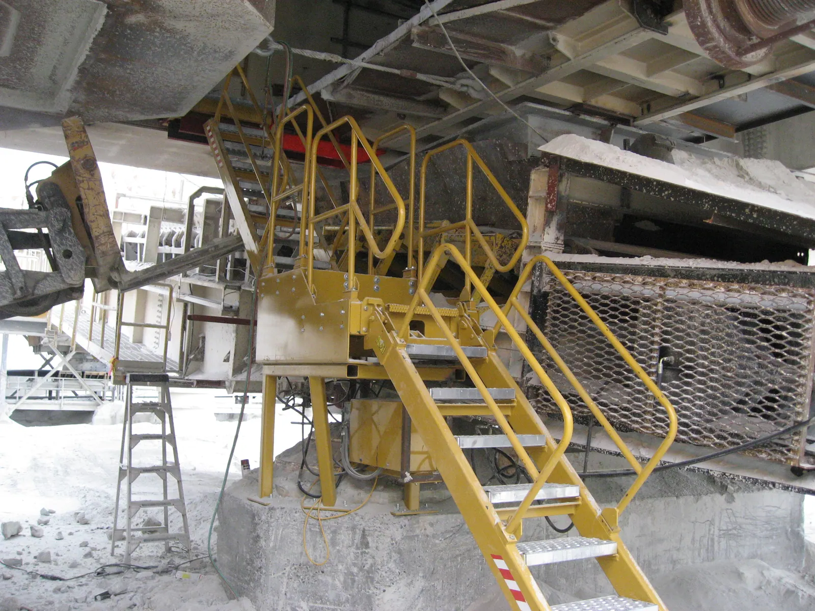 Plataforma e escada de acesso com corrimão em uma estação industrial