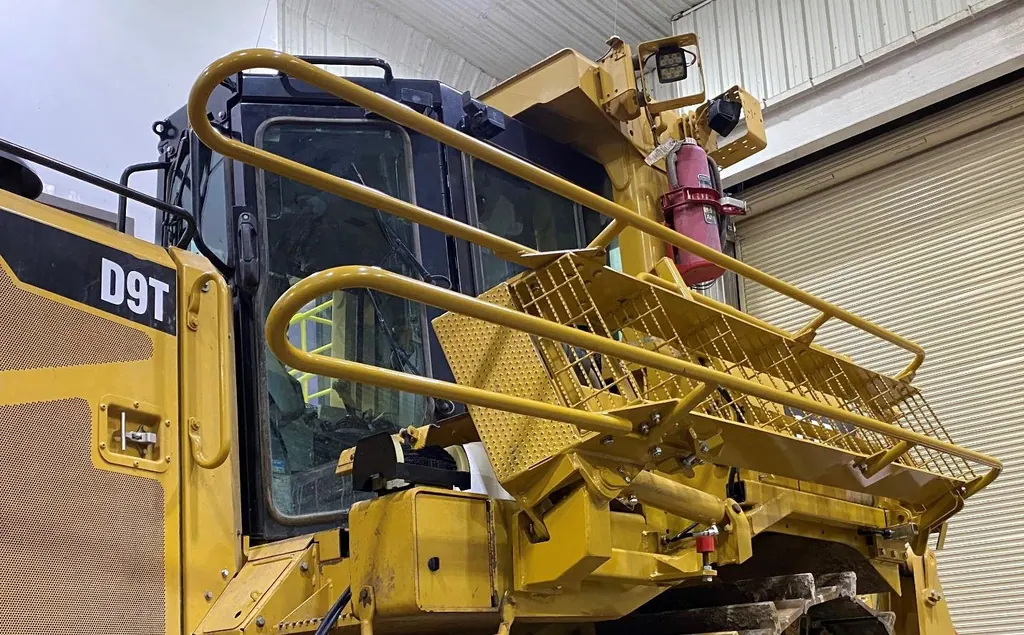Escada de acesso com corrimão instalada em um trator de esteira D9T
