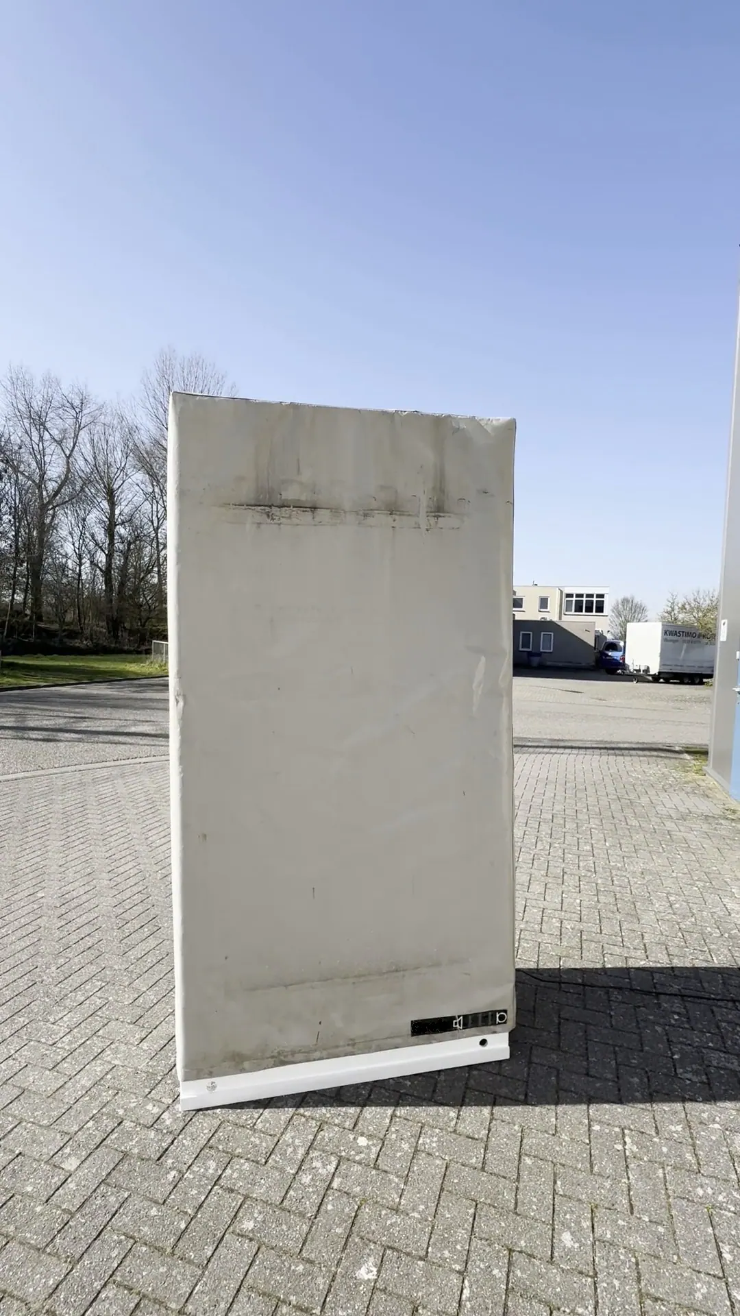Gerador subsônico DGS-AG com cobertura clara em um pátio pavimentado, sob céu azul