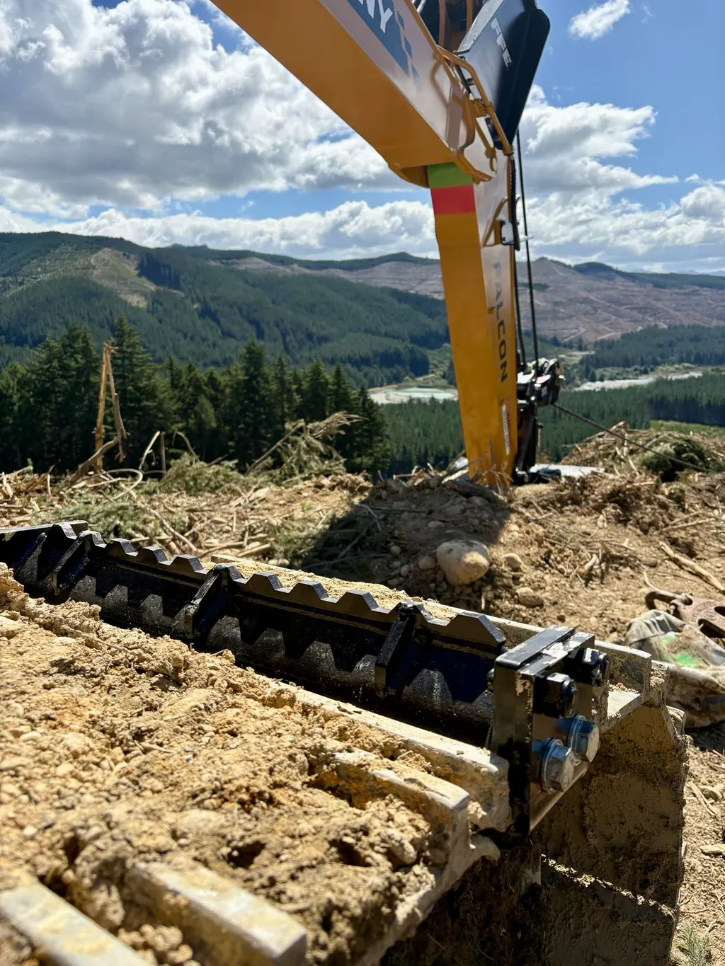 Garra MightyGrip instalada na esteira de aço de uma escavadeira, em terreno de lama