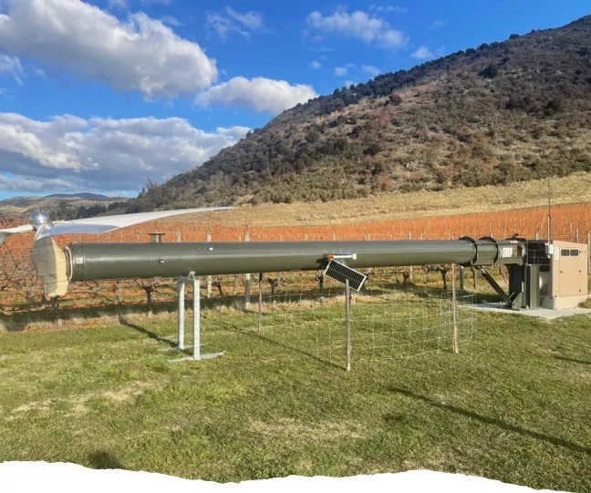 Torre pivotante do ventilador anti-geada abaixada na horizontal, ao pé de uma montanha